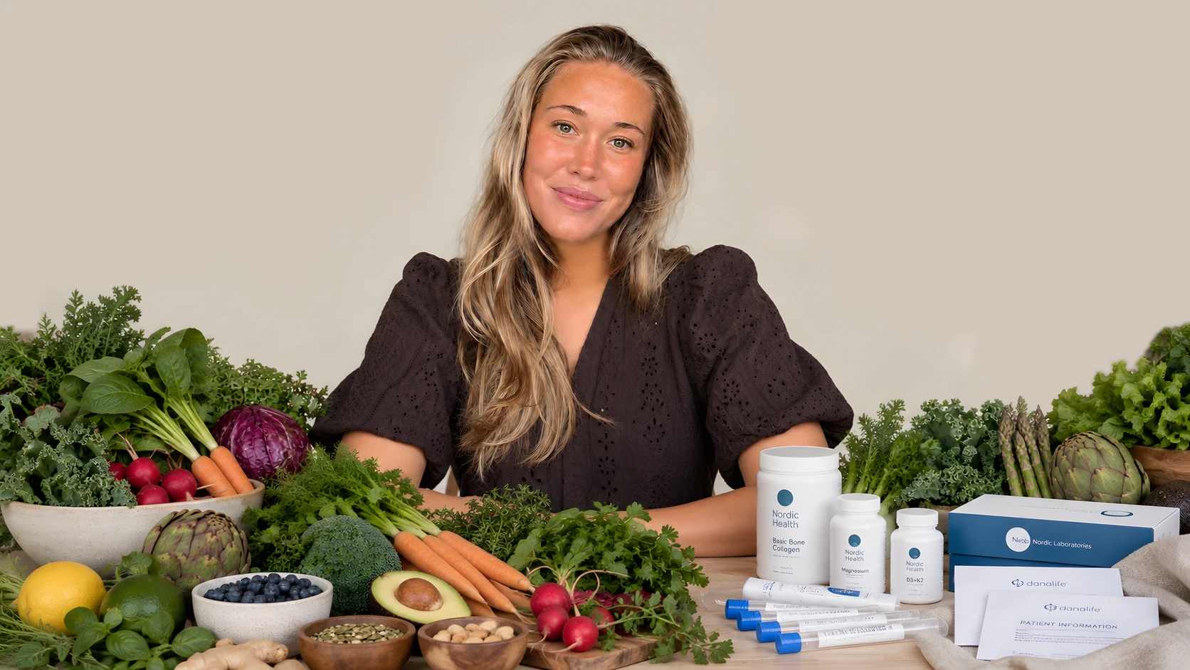 Emilie, hormonterapeut hos Lumea Healing, bag et bord fyldt med friske grøntsager